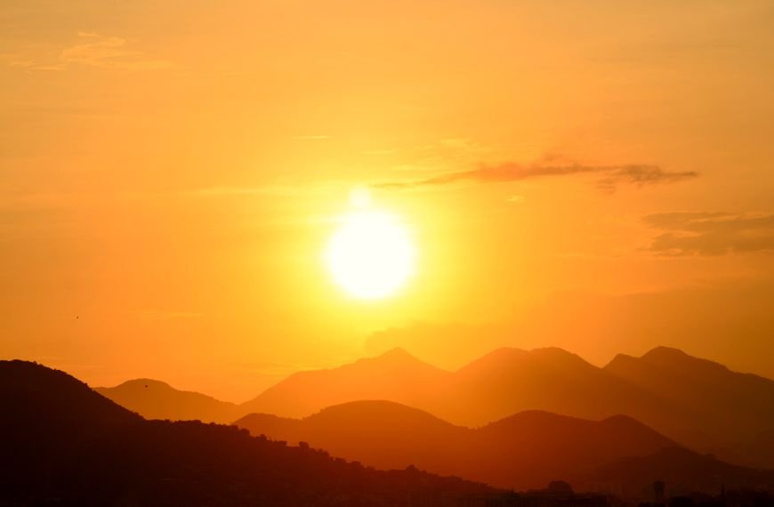 Stunning sunset over Rio de Janeiro's mountains, capturing the vibrant golden hues and silhouettes.