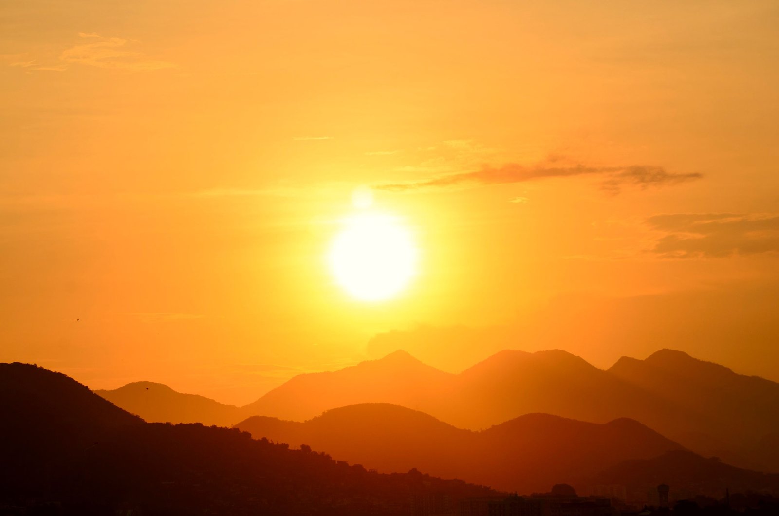 Stunning sunset over Rio de Janeiro's mountains, capturing the vibrant golden hues and silhouettes.